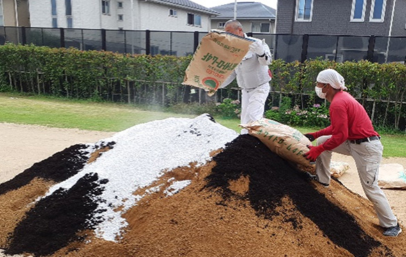 改良材を土に混ぜ込む様子